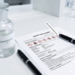 Professional Safety Data Sheet (SDS) document with red GHS hazard pictograms on a lab desk